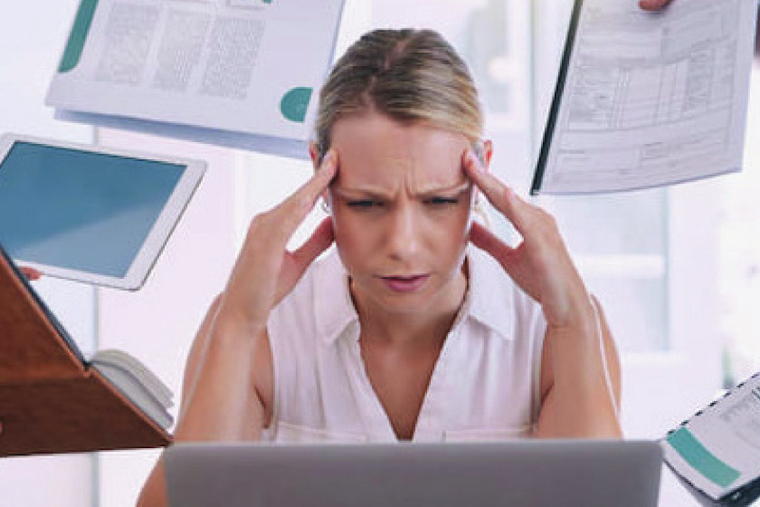 Donna al computer con segni di stress lavorativo – evento sullo stress lavoro-correlato